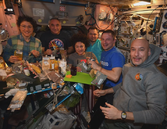 La tripulación que compartió una comida especial de Acción de Gracias a bordo de la <strong>Estación Espacial</strong> en 2019 (de izquierda a derecha, <strong>Christina Koch</strong> (NASA), <strong>Alexander Skvortsov</strong> (Roscosmos), <strong>Jessica Meir</strong> (NASA), <strong>Oleg Skripochka</strong> (Roscosmos), <strong>Andrew Morgan</strong> (NASA) y <strong>Luca Parmitano</strong> (ESA-Italia)