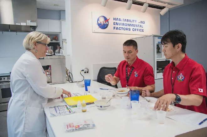 Vickie Kloeris dialoga con los astronautas Kjell Lindgren (NASA) y Kimiya Yui (JAXA), ingenieros de vuelo de la Expedición 44/45 que viajarían a la Estación Espacial Internacional en 2014, durante una sesión de prueba de alimentos.