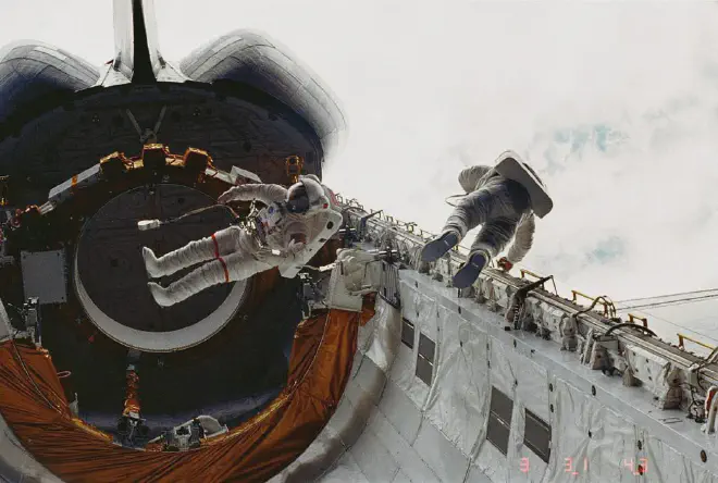 Los astronautas Story Musgrave, izquierda, y Don Peterson flotan en la bahía de carga del transbordador espacial Challenger